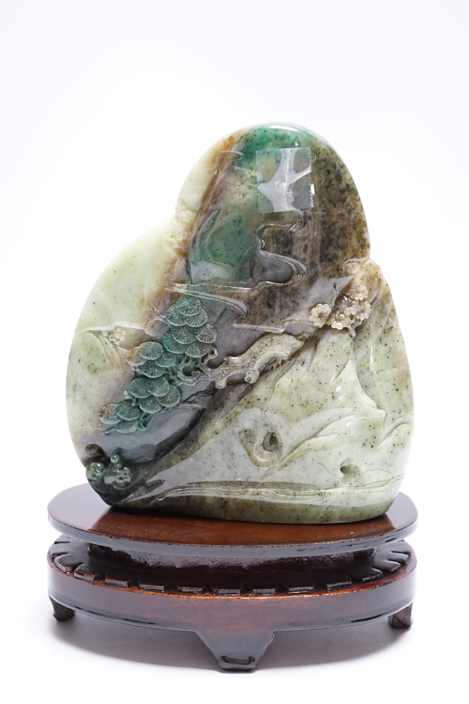 A Chinese jadeite boulder carving on hardwood stand, 17cm high